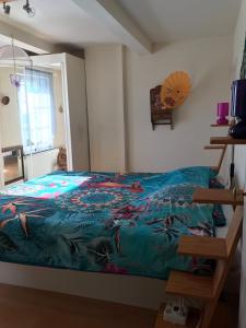 1 dormitorio con 1 cama con manta azul en Gîte Au Corti Pierros, en Houyet