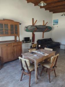 sala de estar con mesa de madera y sillas en Culoteland en Necochea