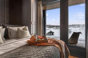 a bedroom with a bed and a window with a view at Kikut Alpine Lodge 9103 in Geilo