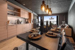 une salle à manger avec une table et une cuisine dans l'établissement Kikut Alpine Lodge 9103, à Geilo