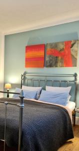 a bedroom with a bed with two paintings on the wall at Seesterne City in Konstanz