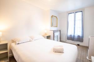 una camera bianca con un grande letto bianco e una finestra di Petit T2 Centre-Ville a Tours
