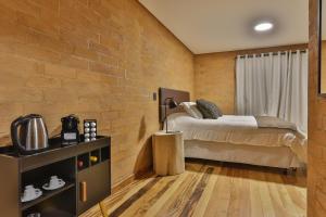 a bedroom with a bed and a brick wall at DOM Hotel in Campos do Jordão