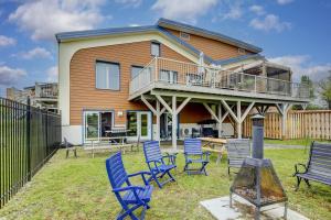 a house with blue lawn chairs and a balcony at Nouveau - Bord de fleuve, Mont Sainte-Anne et + ! in Sainte-Anne-de-Beaupré