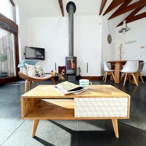 a living room with a coffee table and a fireplace at Merlin Farm Cottages short walk to Mawgan Porth Beach and central location in Cornwall in Mawgan Porth