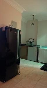 a kitchen with a black refrigerator in a room at Comfy Apartment with private yard in 6 October city Cairo in 6th Of October