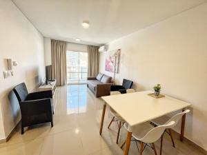 a living room with a table and chairs and a couch at Torre Leonardo Carlos Paz in Villa Carlos Paz