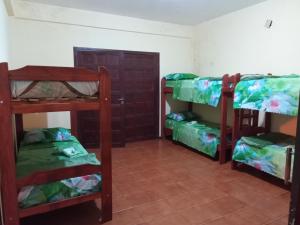 Habitación con 3 literas y puerta en Tucán Alojamiento en Puerto Iguazú