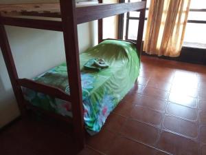 a bunk bed with a green sheet on the bottom bunk at Tucán Alojamiento in Puerto Iguazú