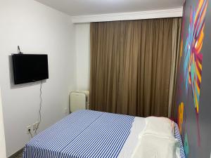 Habitación de hotel con cama y TV en Apartamento perfeito e na melhor localização de Goiânia insta thiagojacomo, en Goiânia