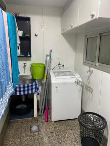 cocina pequeña con fregadero y nevera pequeña en Apartamento perfeito e na melhor localização de Goiânia insta thiagojacomo, en Goiânia