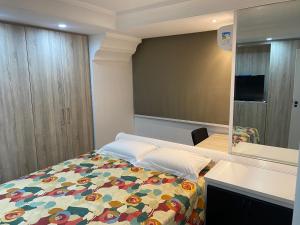 1 dormitorio con cama y espejo en Apartamento perfeito e na melhor localização de Goiânia insta thiagojacomo, en Goiânia