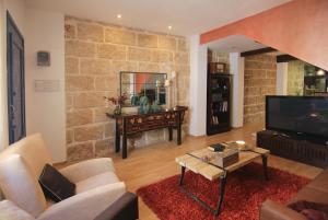 a living room with a couch and a tv at Casa Marrón Boutique Home in Benissa