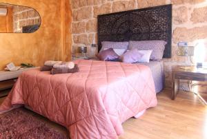 um quarto com uma cama com um edredão rosa em Casa Marrón Boutique Home em Benissa