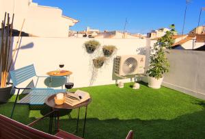 a small backyard with green grass and a wall at Casa Marrón Boutique Home in Benissa