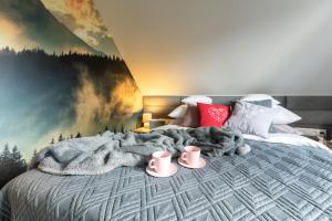 Dormitorio con cama con manta y pintura en Zacisze Pod Śmielcem, en Jelenia Góra-Jagniątków