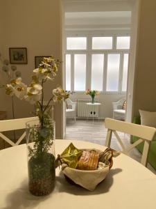 a table with a vase and a bowl of food on it at A casa da Carlo in Palermo