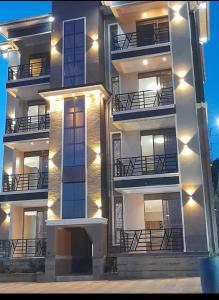a large apartment building with balconies at night at nostiQ homes in Kampala