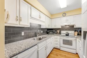 a kitchen with white cabinets and a sink at Summerwind Cottage 1157 in Seabrook Island