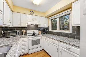 a kitchen with white cabinets and white appliances at Summerwind Cottage 1157 in Seabrook Island +33 photos