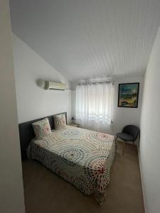 カイエンヌにあるNANA COCOONING- C42- Vue Panoramique - Appartement Cosy et Lumineux- Cuisine équipée- CLIM-Terrasseのベッドと椅子のある寝室