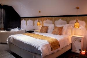 1 dormitorio con 1 cama blanca grande y lavamanos en B&B 1001 nacht, en Zonhoven