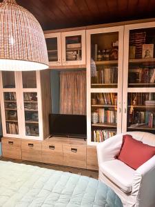sala de estar con TV y silla blanca en DandyVillas-Vintage Cottage House-Pelion-Argalasti-Kallithea, en KallithÃ©a