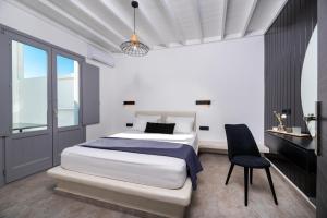 a bedroom with a bed and a desk and a chair at Filoxenia Luxury Villas in Perissa +26 photos