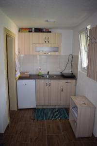 a kitchen with a white refrigerator and a sink at Apartmani Gočki San in Biserske Kuće