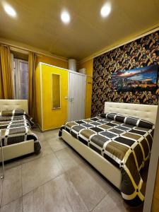 2 camas en una habitación con paredes amarillas en Hotel B&B Spaccanapoli, en Nápoles