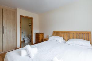 1 dormitorio con 2 camas blancas y baño en Belarmine, en Stepaside