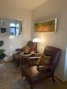 uma sala de estar com cadeiras, uma mesa e um candeeiro em Kongens Apartment St Joseph em Kristiansand