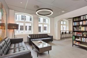 a waiting room with couches and a table and books at Kongens Apartment St Joseph in Kristiansand