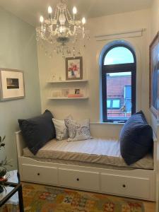 a bed with pillows and a window in a room at Kongens Apartment St Joseph in Kristiansand