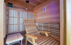a wooden sauna with a wooden chair and a bench at Nice Home In Zelezna Gora With Sauna in Grabrovnik