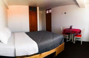 una camera con letto, tavolo e sedie di Alpino Guest House a Huaraz