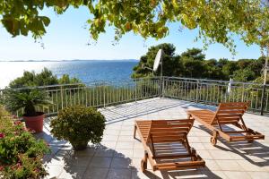 two chairs and a table on a patio overlooking the water at Rato in Murter