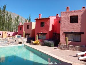 a house with a swimming pool in front of a house at Colores de Purmamarca in Purmamarca