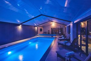 a swimming pool with blue lighting in a house at Woodland House in Belbroughton