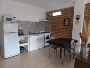 a kitchen with a black table and a white refrigerator at gammarooms in Neuquén