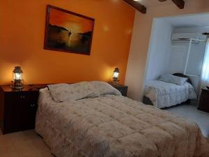 ein Schlafzimmer mit 2 Betten und einem Wandgemälde in der Unterkunft Cabañas Cerros Azules en La Rioja Alojamiento Temporario in La Rioja