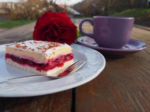 a piece of cake on a plate next to a cup of coffee at Merkež Guest House in Bizeljsko