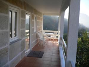 een balkon van een huis met een tafel en stoelen bij Maria João in Paredes de Coura