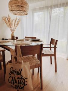 een eetkamer met een tafel en stoelen en een tas bij Breeze Albatross in Ķesterciems