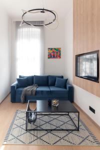 un salon avec un canapé bleu et une table dans l'établissement Deluxe Dunavska Apartment 4, à Novi Sad