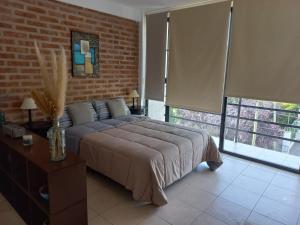 a bedroom with a large bed and a brick wall at gammarooms in Neuquén