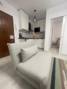 a white couch in a room with a kitchen at Renovated modern apartment in the city center in Santa Cruz de Tenerife