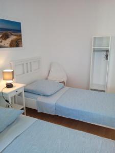 a bedroom with two beds and a table with a lamp at L'EUROPEEN - Conseil de l 'Europe - Near Center - Homeoffice in Strasbourg
