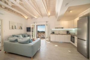 Una sala de estar con un sofá y una cocina. en Fiscardo Luxury Stone Villa Suzana ,with sunset view!, en Fiskardho