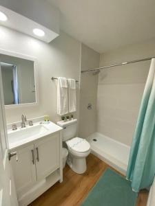 a white bathroom with a sink and a toilet and a tub at Sea Dip Resort Studios! in Daytona Beach